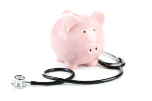 Pink Piggy Bank With Stethoscope Isolated On A White